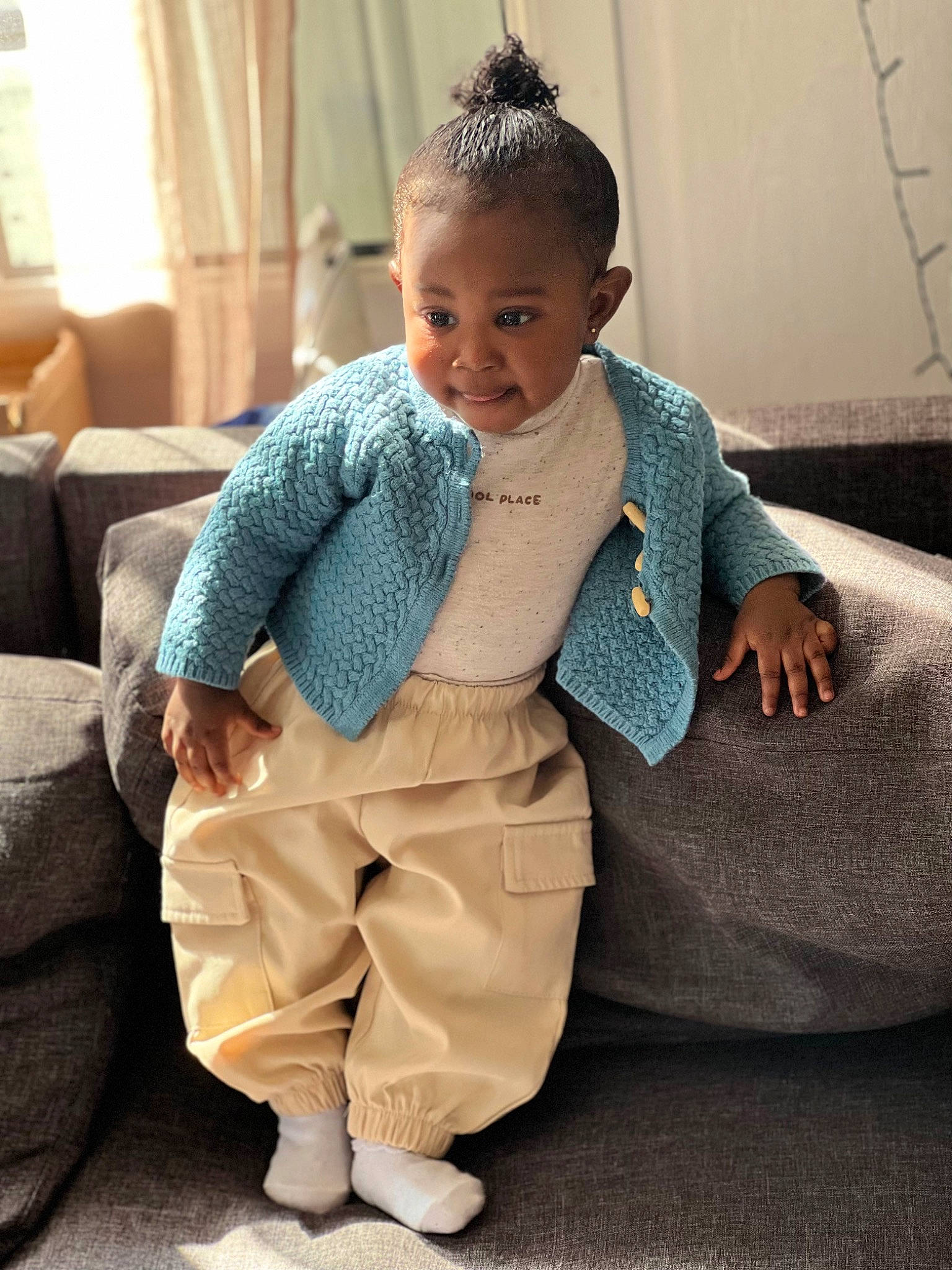 Daïlys participe au concours pour gagner de l'argent avec cette photo : baby_toddler_clothing, child, clothing, comfort, couch, curtain, fashion_accessory, flooring, formal_wear, fun, hair, happy, jewellery, neck, outerwear, pattern, person, sitting, sleeve, smile
