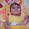 baby, child, yellow_dress, headband, bow, smiling, face, blue_eyes, blanket, smiley_faces, number_one, celebration, portrait, cute, happy, infant, hand, fabric, colorful, background