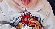Inaya participe au concours pour gagner de l'argent avec cette photo : baby, child, tongue_out, smiling, white_clothing, unicorn, sequins, cute, indoor, soft_lighting, happy, infant, person, portrait, cozy, warm, playful, small_hands, sitting, apparel