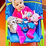 baby, child, infant, onesie, headband, toy, plush_toy, owl_toy, pig_toy, baby_rocker, fisher_price, blue, pink, green, orange_floor, indoor, cute, seated, looking_at_camera, curious