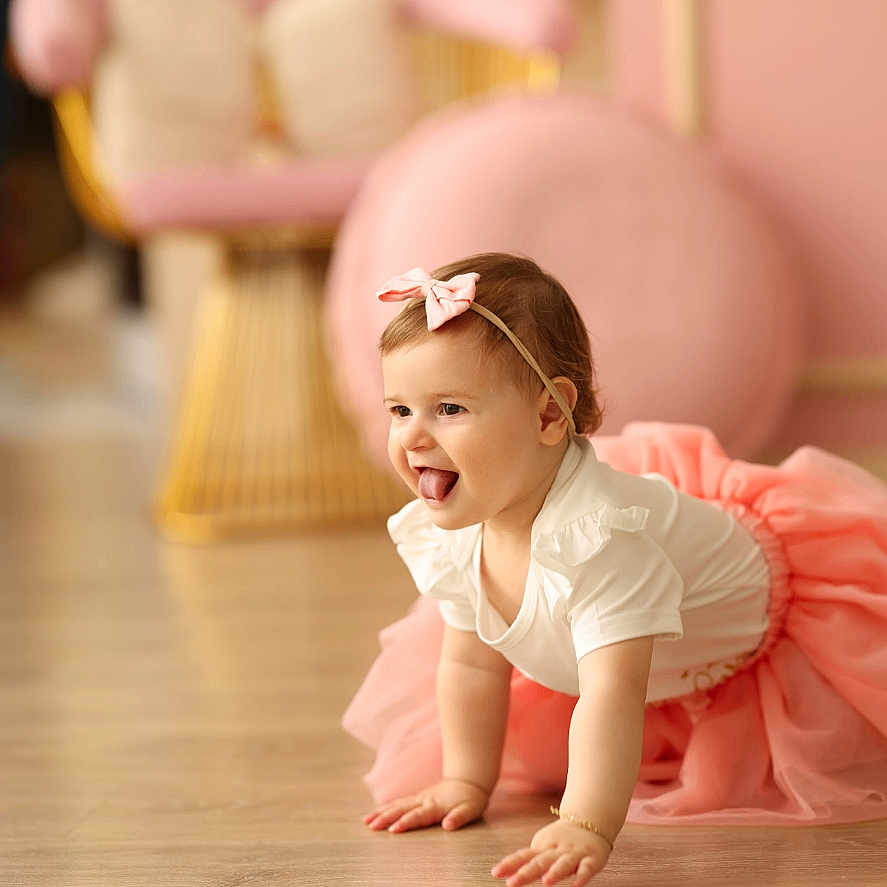 Daisy Bejkollari joined the competition — help win amazing prizes! baby, chair, child, crawling, cushions, cute, furniture, girl, happy, headband, home, indoor, pink, playful, portrait, smiling, soft_lighting, tongue_out, tutu, wooden_floor