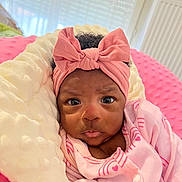 Lucimary participe au concours pour gagner de l'argent avec cette photo : baby, blanket, bow, closeup, cozy, expression, eyes, face, headband, indoors, infant, newborn, onesie, pillow, pink_clothing, portrait, radiator, skin, soft_texture, window