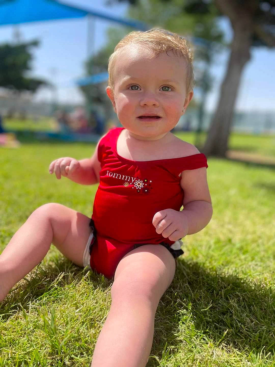 Annalynn is registered to the contest to win money with this photo: baby, baby_toddler_clothing, face, finger, fun, grass, happy, head, leg, leisure, mammal, people, people_in_nature, person, pink, plant, skin, smile, sunlight, thigh