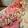 baby, sleeping, infant, blanket, headband, floral_pattern, pink_clothing, cozy, cute, wrapped, newborn, soft, indoors, face, child, peaceful, fabric, closeup, person, resting