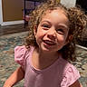 Isabella joined the competition — help win amazing prizes! child, toddler, smiling, curly_hair, pink_dress, indoor, rug, carpet, fireplace, furniture, home, happy, person, portrait, young_child, cute, playful, girl, living_room, casual