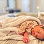 baby, newborn, sleeping, blanket, bed, infant, peaceful, cozy, soft_lighting, face, skin, hand, clothing, indoors, portrait, rest, cute, child, sleep, comfort