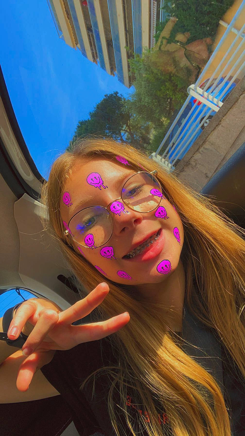 Elsa participe au concours pour gagner de l'argent avec cette photo : automotive_design, brown_hair, eyewear, finger, fun, glass, glasses, hand, happy, human_leg, joy, leisure, luxury_vehicle, magenta, nail, person, selfie, sunglasses, tree, vacation