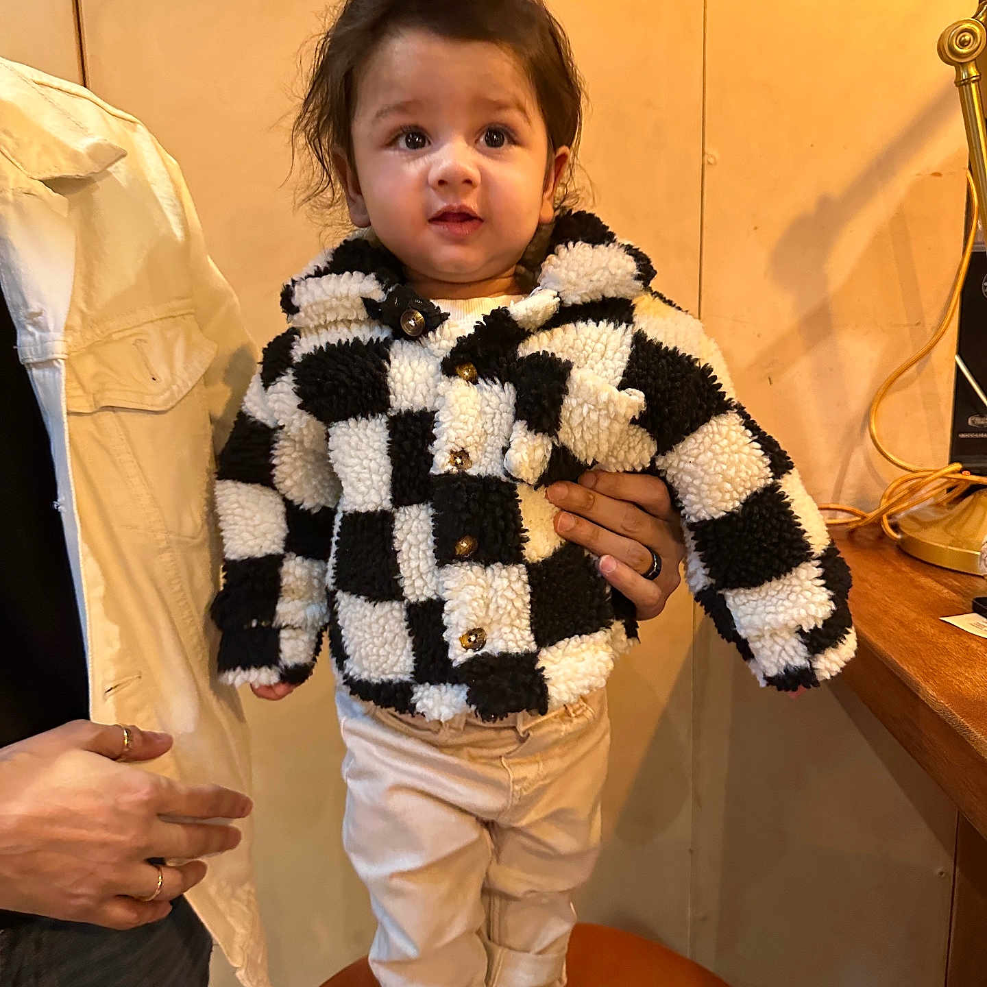 Arkay joined the competition — help win amazing prizes! background, brown_hair, casual, chair, checkered_pattern, child, cute, fashion, hand, indoor, jacket, pants, person, portrait, smiling, standing, support, toddler, warm_lighting, white_shoes