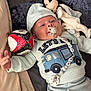 Ayden a rejoint le concours — aidez-le/la à gagner de superbes lots ! baby, infant, pacifier, toy, plush_toy, ball, clothing, sweatshirt, hood, bed, blanket, smiling, happy, child, person, indoor, cute, lying_down, comfort, soft
