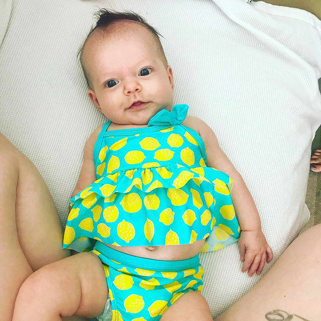 Elliotte is registered to the contest to win money with this photo: baby, baby_products, baby_toddler_clothing, child, design, diaper, finger, pattern, person, polka_dot, product, sitting, stomach, swimwear, toddler, turquoise