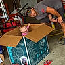 Paisley is registered to the contest to win money with this photo: adult, cap, cardboard_box, casual_clothing, child, concrete_floor, floor, garage, indoor, laughing, man, playful, red_toolbox, smiling, storage, sunglasses, toddler, toolbox, tools, workshop