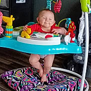 Paisley joined the competition — help win amazing prizes! baby, baby_jumper, child, colorful, cushion, feet, floor, happy, home, indoor, infant, legs, patterned, person, plastic_toys, playful, red_clothing, smiling, toys, wooden_floor