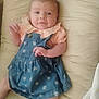Luna is registered to the contest to win money with this photo: baby, infant, child, blue_dress, floral_pattern, peach_top, frilly_collar, cushion, bed, lying_down, face, expression, skin, hand, foot, indoors, soft_lighting, portrait, cute, person