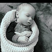 Atles is registered to the contest to win money with this photo: baby, sleeping, blanket, knitted, infant, peaceful, black_and_white, portrait, hands, cute, cozy, child, soft_texture, resting, wrapped, newborn, face, closeup, indoor, calm