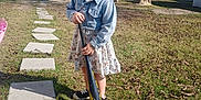 Harlee joined the competition — help win amazing prizes! child, baseball_bat, outdoor, grass, tree, car, path, stepping_stones, denim_jacket, dress, footwear, sunlight, sky, parking_area, curious_expression, person, nature, daytime, shoes, yard