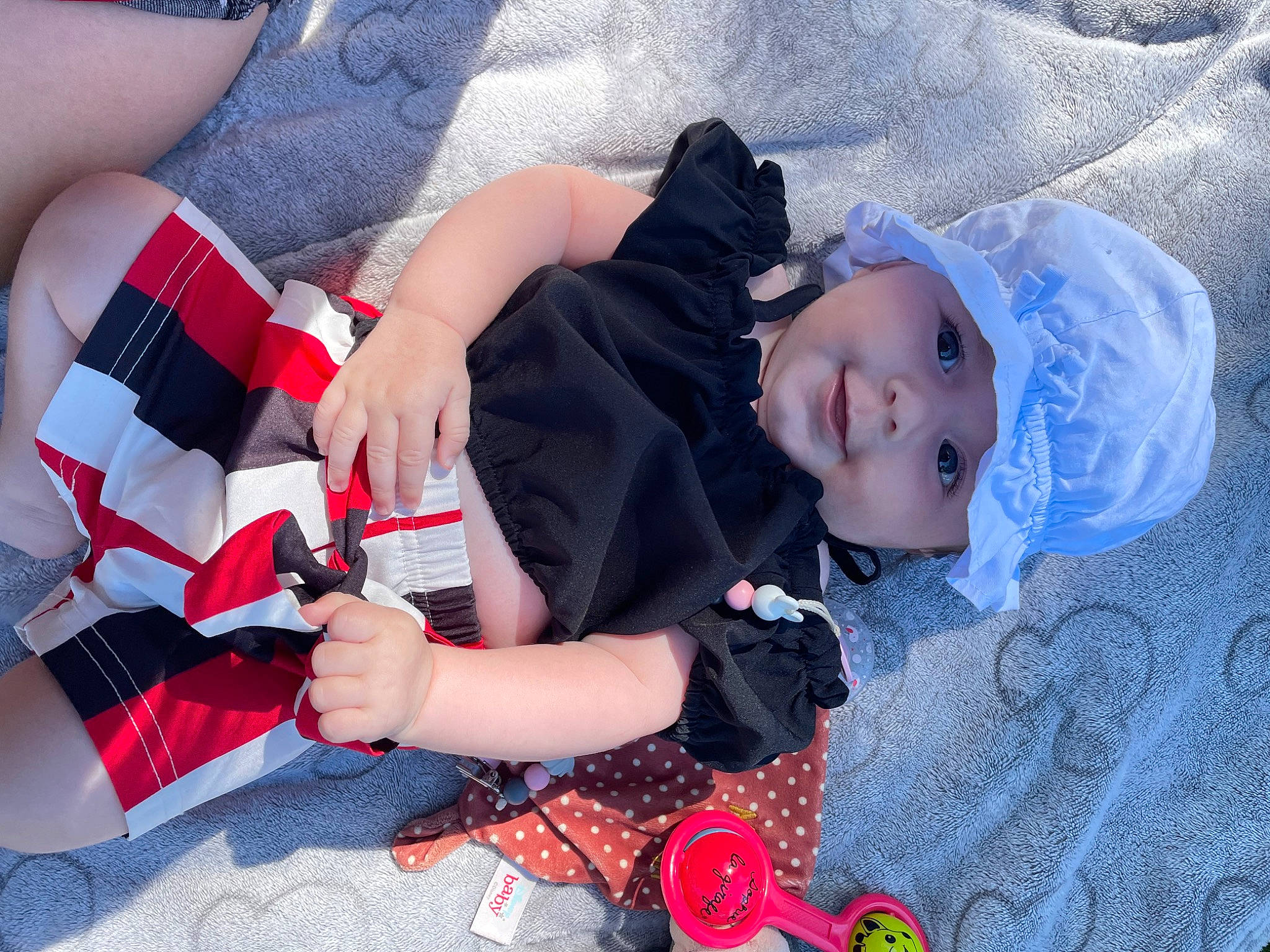 Savana participe au concours pour gagner de l'argent avec cette photo : baby, baby_toddler_clothing, blue, carmine, child, comfort, electric_blue, fashion_accessory, fun, gesture, grass, headwear, human_leg, nail, pattern, person, plaid, product, thigh, thumb