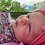 baby, infant, close_up, face, headband, pink, bow, blanket, floral_pattern, outdoor, trees, sky, clouds, child, cute, portrait, soft_skin, expression, person, nature