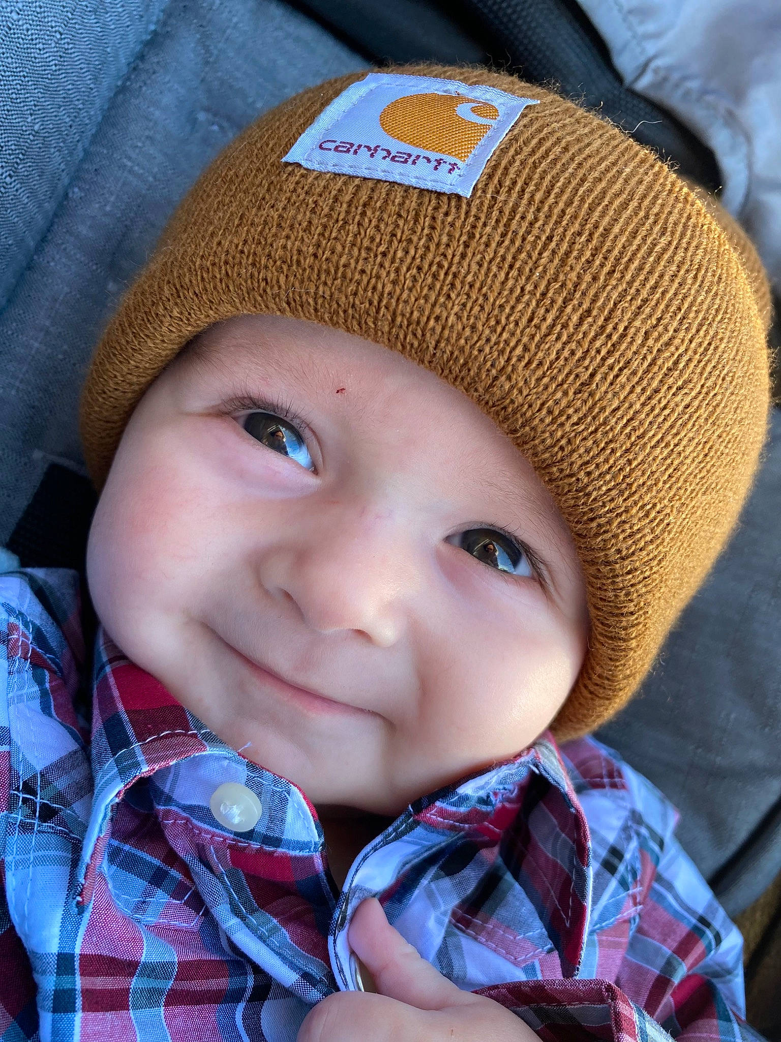 Noah is registered to the contest to win money with this photo: baby, cap, cheek, child, chin, collar, cool, electric_blue, face, hat, head, headwear, joy, lip, organ, person, plaid, skin, smile, sun_hat