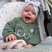 Lexie joined the competition — help win amazing prizes! baby, blanket, blue_eyes, child, cozy, cute, green_sweater, hand, happy, headwrap, heart_pattern, infant, knitted, outdoor, pink, portrait, smiling, soft, stroller, white