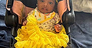 Brooklynne is registered to the contest to win money with this photo: baby, baby_girl, black_hair, blanket, car_seat, child, clothing, cute, fabric, hair_accessories, indoor, infant, person, portrait, seated, smiling, soft_texture, white_socks, yellow_skirt, young_child