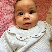 Tesnim participe au concours pour gagner de l'argent avec cette photo : baby, infant, face, eyes, white_clothing, heart_pattern, pink_towel, cute, portrait, child, soft_texture, closeup, adorable, young, laying_down, expression, skin, head, mouth, indoor