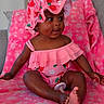 baby, infant, child, pink, blanket, hat, strawberry_pattern, clothing, sitting, cute, smiling, indoors, soft_texture, portrait, happy, face, foot, hand, comfortable, cozy