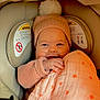 baby, beanie, blanket, candid, car_seat, child, close_up, cozy, fabric, hand, heart_pattern, infant, nasal_cannula, oxygen_tubing, pink, pompom, portrait, seat_padding, smile, warning_label