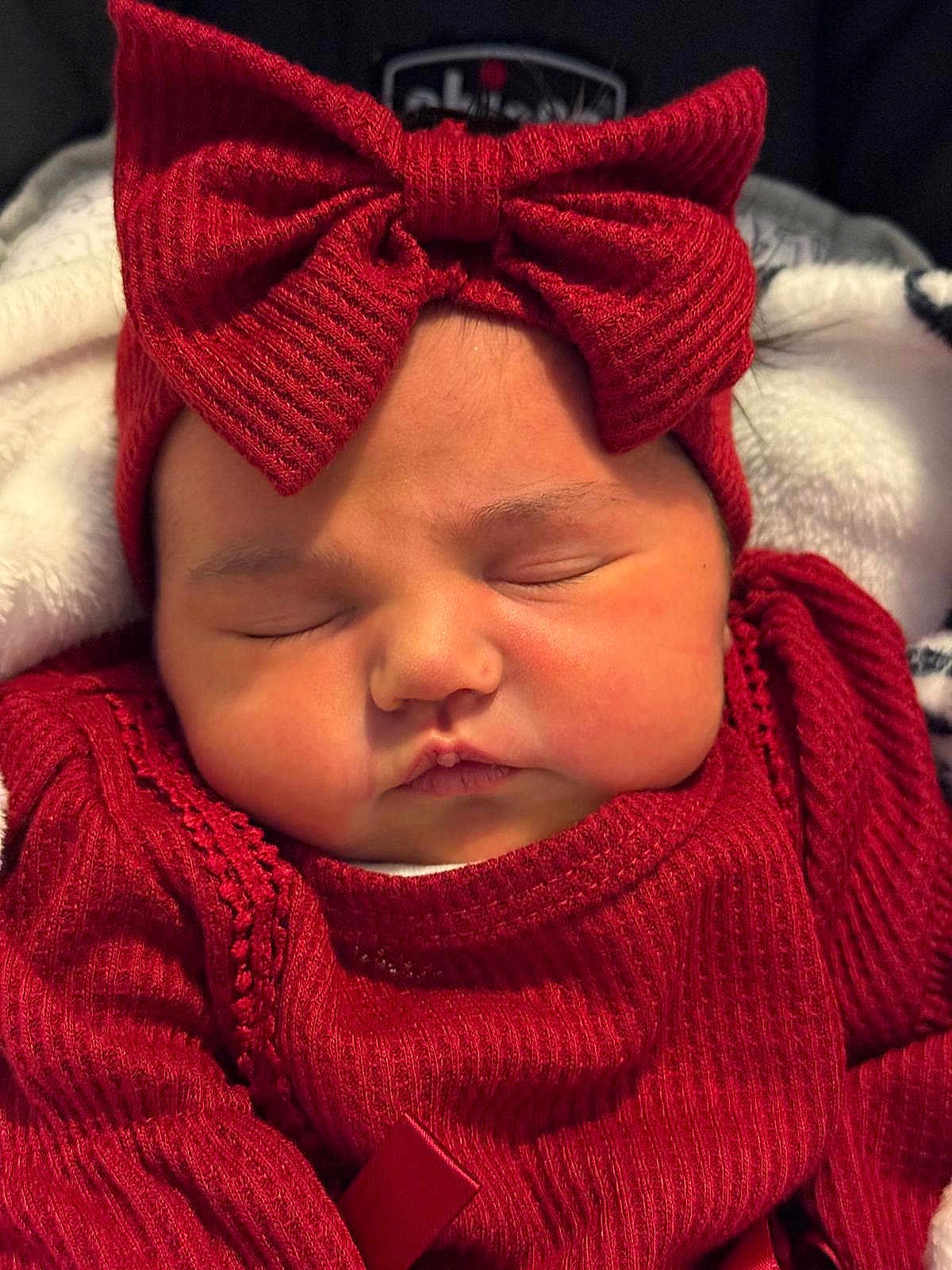 Aurora joined the competition — help win amazing prizes! baby, sleeping, red_clothing, headband, bow, infant, cute, face, closed_eyes, soft_texture, warm, child, portrait, cozy, newborn, adorable, knitwear, resting, indoors, blanket
