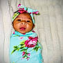 Nevaeh is registered to the contest to win money with this photo: baby, bed, blanket, bonnet, clothing, crib, dress, face, furniture, happy, hat, head, newborn, person, photography, portrait, purple, quilt, smile, towel