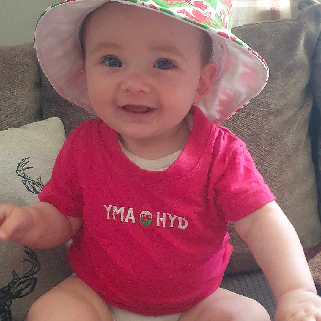 Rini Ann joined the competition — help win amazing prizes! architecture, baby, bonnet, cap, clothing, couch, cushion, diaper, face, furniture, hat, head, homedecor, person, photography, portrait, shorts, sitting, sunhat, t_shirt