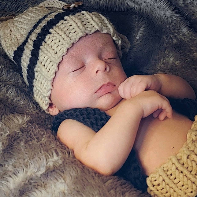 Grant is registered to the contest to win money with this photo: arm, baby_sleeping, baby_toddler_clothing, cap, cheek, comfort, eye, eyelash, finger, gesture, hand, head, headwear, iris, lip, mammal, neck, person, skin, sleeve