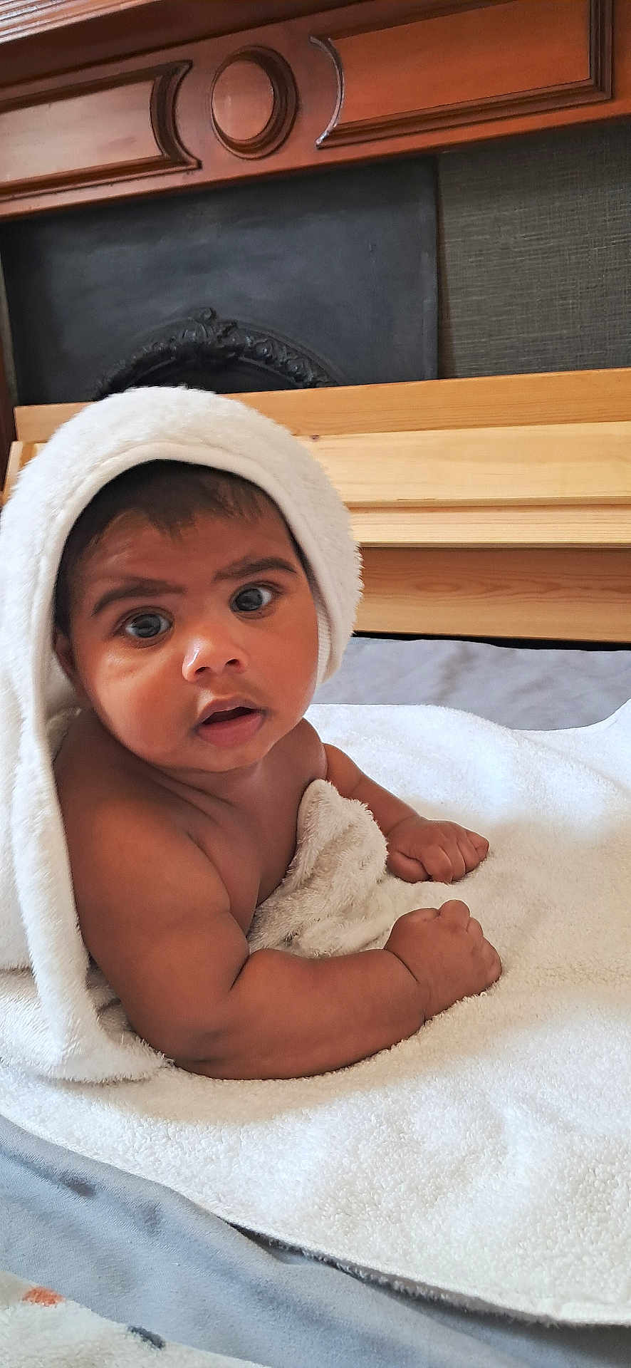Revlon Fernandes is registered to the contest to win money with this photo: baby, towel, blanket, infant, child, skin, face, eyes, hands, expression, indoor, bed, wood, texture, curious, cute, portrait, cozy, soft, warm