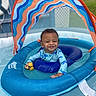 toddler, child, inflatable_pool, float, canopy, rubber_duck, water, swimming_pool, smiling, blue, outdoor, sunny, play, baby, summer, recreation, fun, toy, young_child, happy