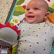 Bastien a rejoint le concours — aidez-le/la à gagner de superbes lots ! baby, smiling, plush_toy, play_mat, infant, clothing, stars_pattern, happy, cute, child, indoor, person, closeup, face, head, joy, colorful, soft_toy, baby_girl, baby_boy