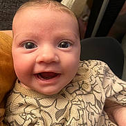 Marley is registered to the contest to win money with this photo: baby, smile, face, eyes, infant, clothing, patterned_outfit, close_up, happy, cute, person, skin, expression, young_child, indoors, portrait, baby_girl, baby_boy, human, child