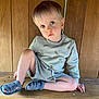 toddler, child, blue_eyes, sitting, wooden_bench, wooden_wall, casual_clothing, sweater, sandals, indoors, natural_light, portrait, cute, young_child, relaxed, bare_legs, hand_on_bench, serious_expression, short_hair, light_hair