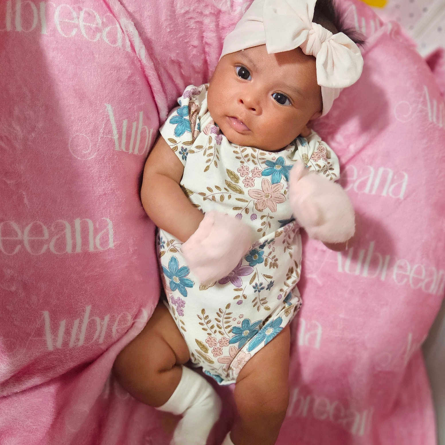 Aubreeana is registered to the contest to win money with this photo: adorable, baby, blanket, bow, child, cozy, cute, floral, headband, indoors, infant, lying_down, mittens, newborn, onesie, person, pink, portrait, sleepwear, soft
