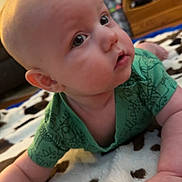 Harrison joined the competition — help win amazing prizes! baby, infant, child, green_clothing, blanket, floor, indoor, furniture, face, skin, hand, curious, eyes, head, cute, toddler, home, soft_texture, carpet, room