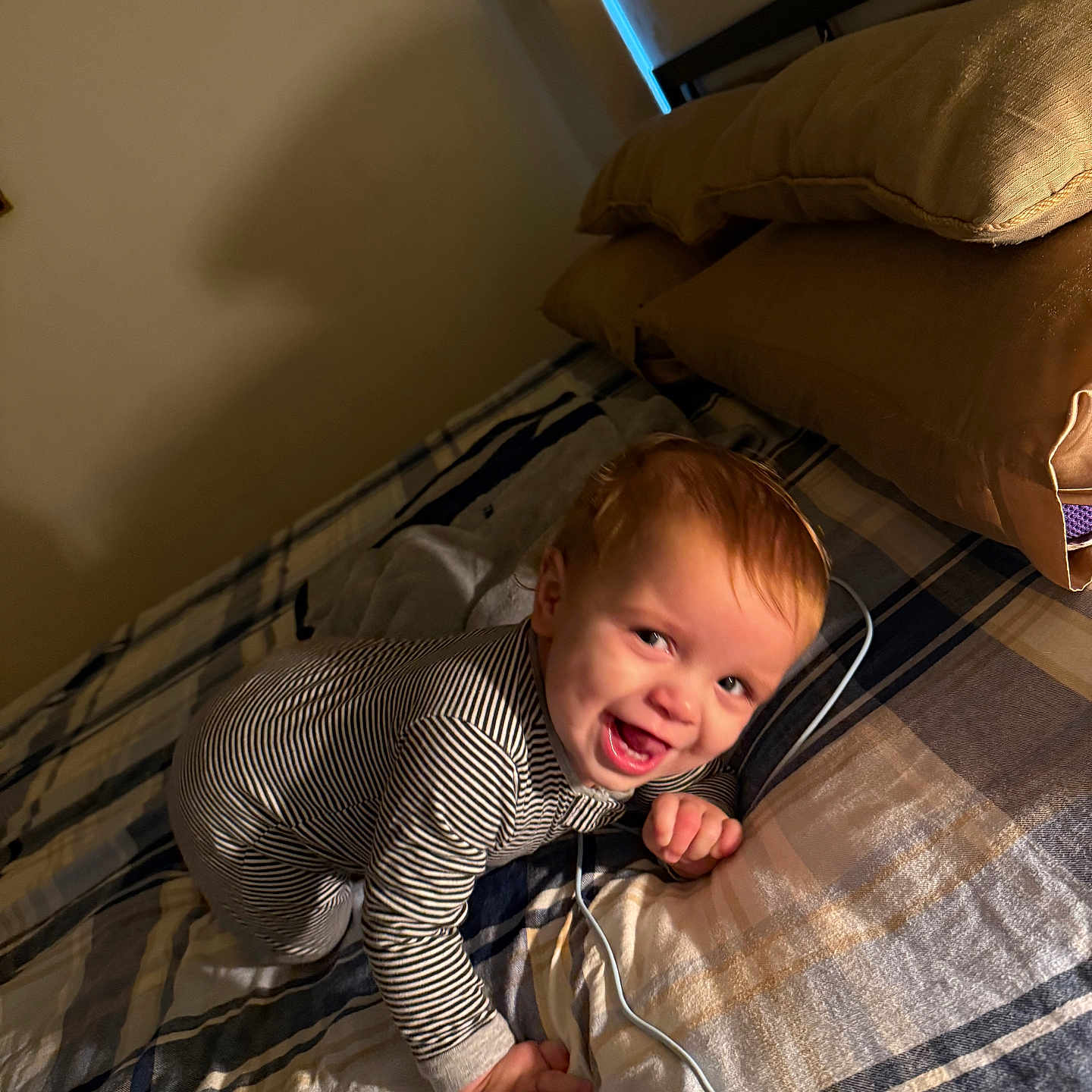 Noah joined the competition — help win amazing prizes! baby, bed, child, cozy, crawling, cute, face, happy, home, indoor, light, person, pillow, plaid_blanket, playful, shadow, smile, striped_pajamas, warm_lighting, young_child
