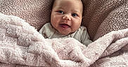 Leah joined the competition — help win amazing prizes! baby, blanket, cushion, smile, happy, face, infant, cozy, pink, texture, outdoor, grass, chair, seat, portrait, person, warm, comfort, clothing, cute