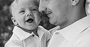 Dawson is registered to the contest to win money with this photo: baby, child, young_man, portrait, black_and_white, smiling, outdoor, nature, happy, father_and_son, family, holding, close_up, casual_clothing, short_hair, love, affection, cute, people, emotion