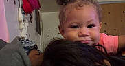 Eliana joined the competition — help win amazing prizes! baby, child, person, adult, hair, face, indoor, room, wall, sofa, purse, head, cute, smile, curly_hair, casual_clothing, relaxing, family, toddler, closeup
