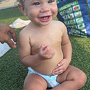 Eliana is registered to the contest to win money with this photo: toddler, child, smiling, curly_hair, diaper, outdoor, grass, playful, happy, baby, person, hand, bag, vegetables, bench, sunlight, casual, cute, skin, sitting