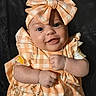 baby, infant, smiling, dress, bow, headwear, cheek, cute, child, happy, portrait, clothing, pattern, fabric, sleeve, skin, person, young, face, background