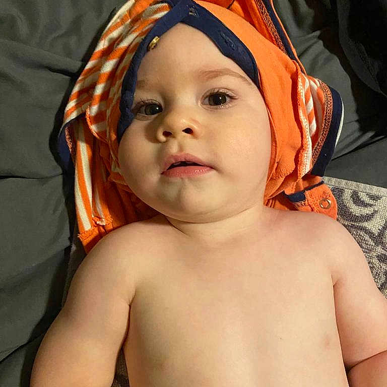 Daniel is registered to the contest to win money with this photo: accessories, baby, bandana, bed, bonnet, cap, clothing, face, happy, hat, head, headband, hood, person, photography, portrait, sad, skin, smile, swimwear