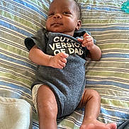 Semaj joined the competition — help win amazing prizes! baby, infant, onesie, clothing, striped_bedspread, lying_down, cute, expression, fist, skin, foot, hand, bed, blanket, child, person, indoor, newborn, smile, portrait