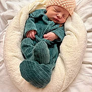 Jade participe au concours pour gagner de l'argent avec cette photo : newborn, baby, sleeping, infant, soft, cushion, blanket, knitted_hat, teal_onesie, cozy, peaceful, closeup, indoors, child, portrait, resting, cute, small_hands, wrapped, comfort