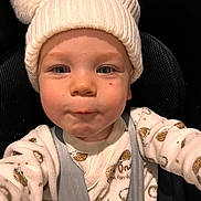 Oscar a rejoint le concours — aidez-le/la à gagner de superbes lots ! toddler, child, baby, hat, knit_hat, pom_poms, onesie, car_seat, seatbelt, cute, face, expression, indoor, warm_clothing, closeup, portrait, infant, childhood, safety, young