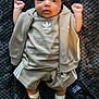 baby, infant, clothing, adidas, socks, shoes, jacket, tshirt, shorts, person, face, skin, hand, fist, blanket, phone, technology, lying_down, indoors, cute