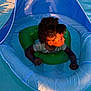 Samani joined the competition — help win amazing prizes! toddler, child, pool, water, float, inflatable, swimming, curly_hair, sunlight, outdoor, summer, fun, play, blue, green, sitting, floating, person, water_toy, recreation